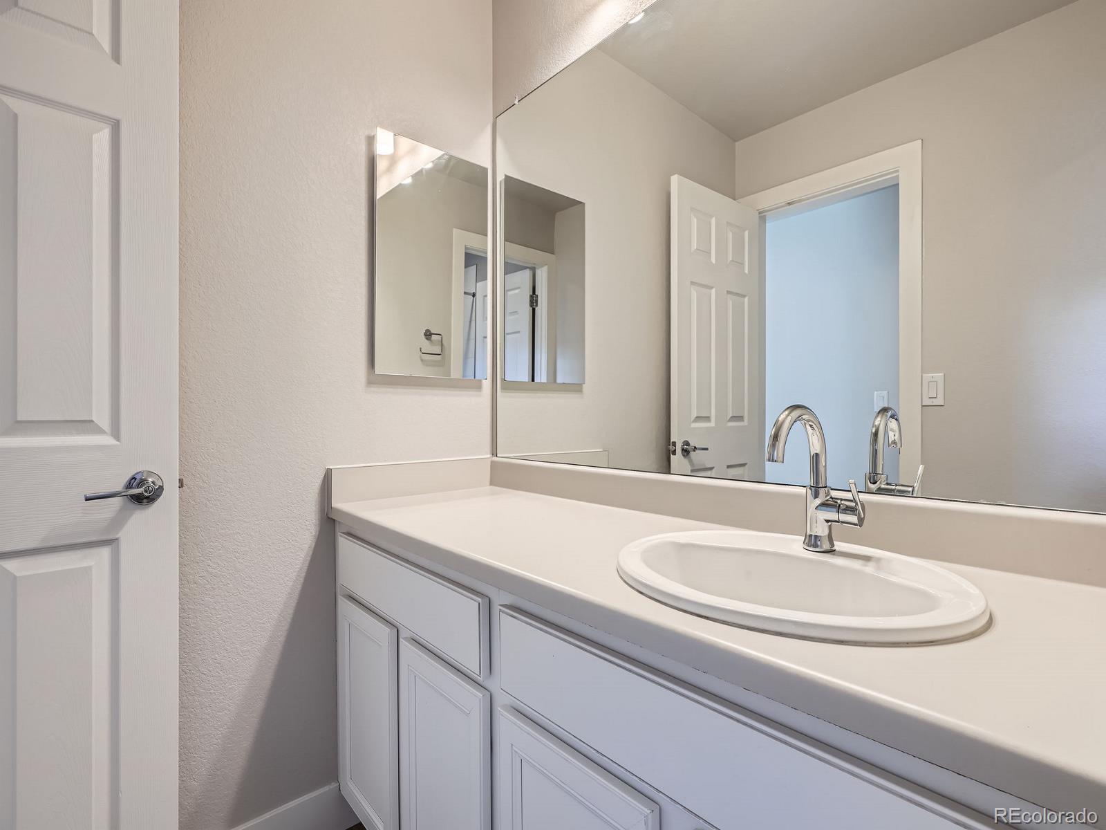4773 Kittredge Street Denver, CO 80239 - Photo 22 of 32 a bathroom with a sink and a mirror