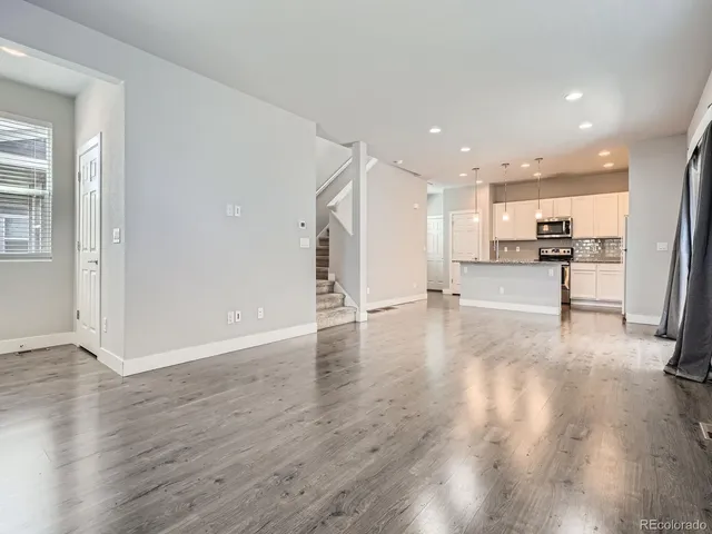 a view of a kitchen with wooden floor and electronic appliances