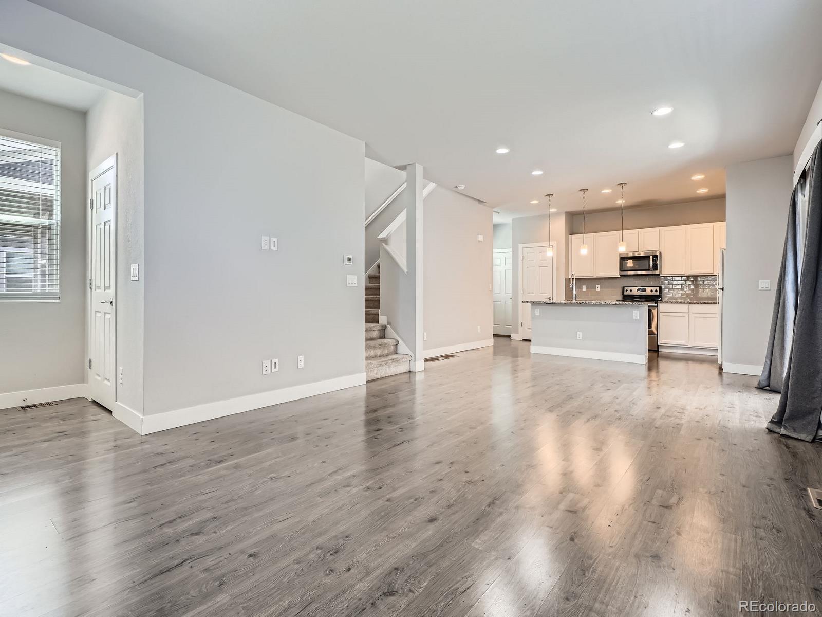 4773 Kittredge Street Denver, CO 80239 - Photo 4 of 32 a view of a kitchen with wooden floor and electronic appliances