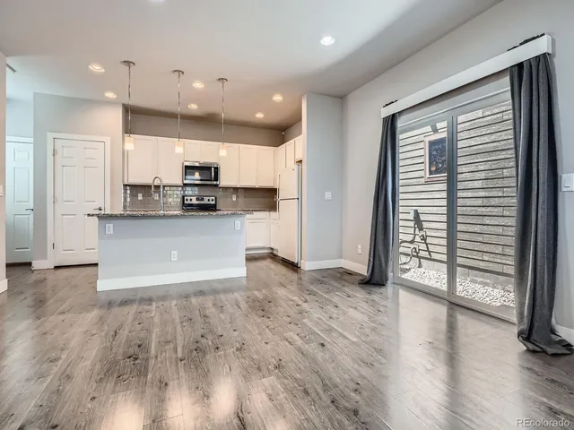 a view of kitchen with wooden floor and electronic appliances