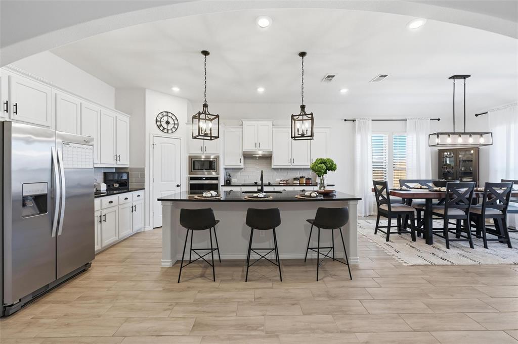 4425 Dandelion Lane Midlothian, TX 76065 - Photo 11 of 40 a kitchen with kitchen island granite countertop a sink a counter top stainless steel appliances and cabinets