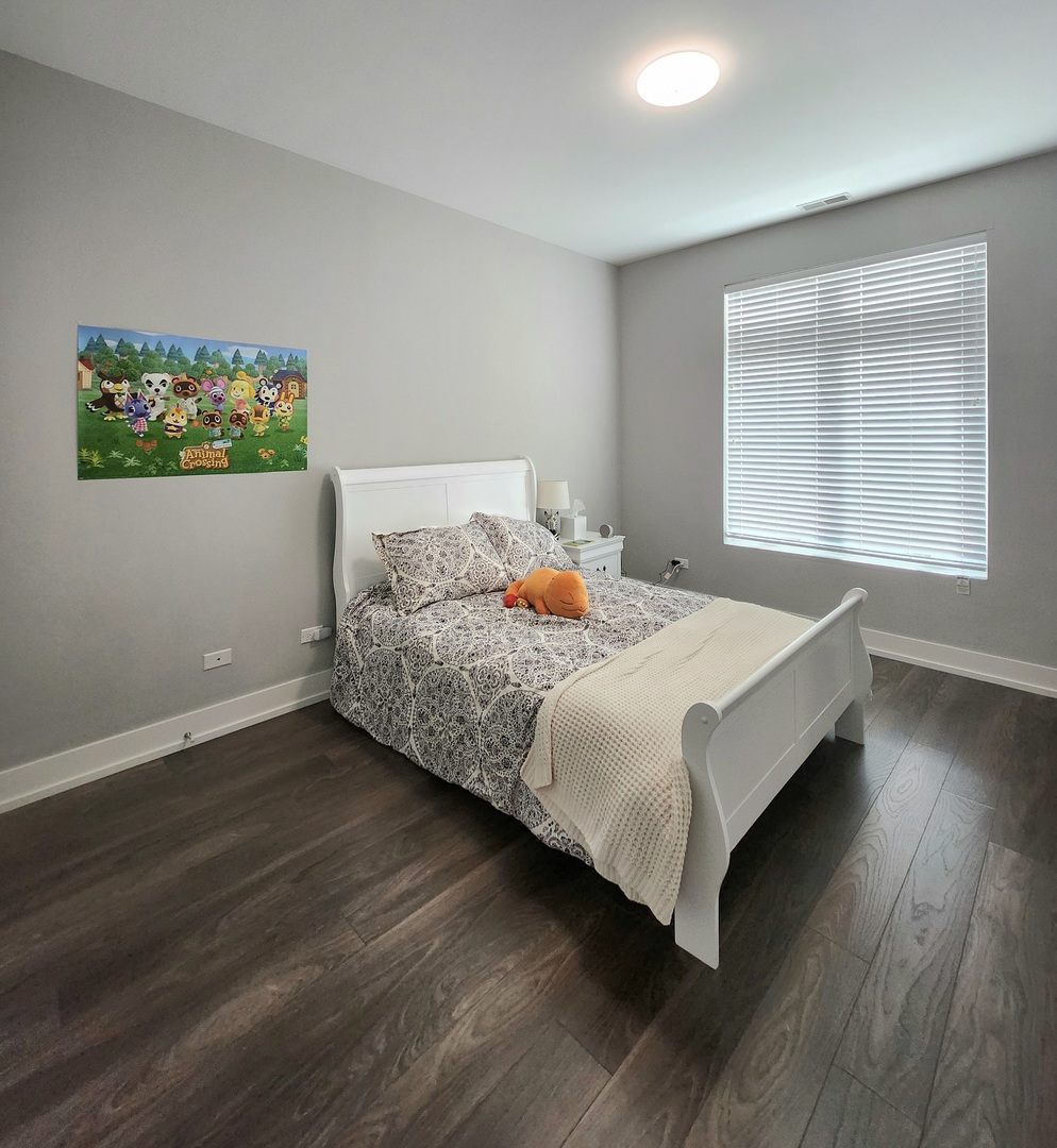 1202 Waukegan Road, Unit 201 Glenview, IL 60025 - Photo 12 of 15 a bedroom with a bed and wooden floor