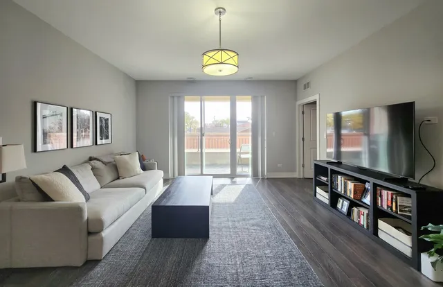 a living room with furniture a window and a flat screen tv