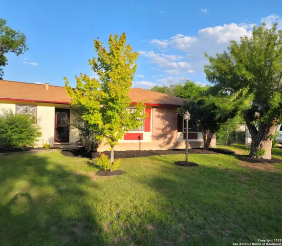 a view of a house with backyard and sitting area