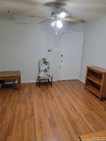 a room with wooden floor and ceiling fan