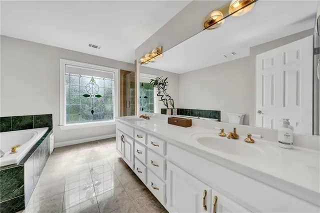 a bathroom with a tub sink and mirror