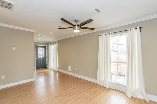 a view of an empty room with wooden floor