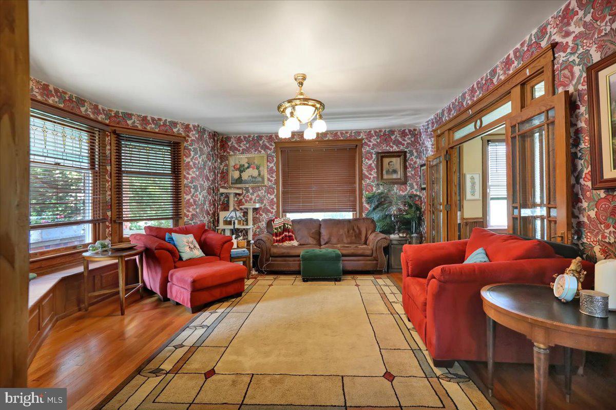 207 State Street Reading, PA 19607 - Photo 11 of 55 a living room with furniture a chandelier a large window and a chandelier