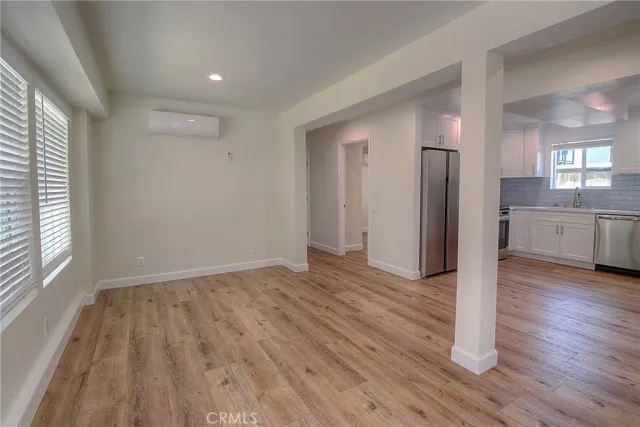 a view of empty room with wooden floor and window
