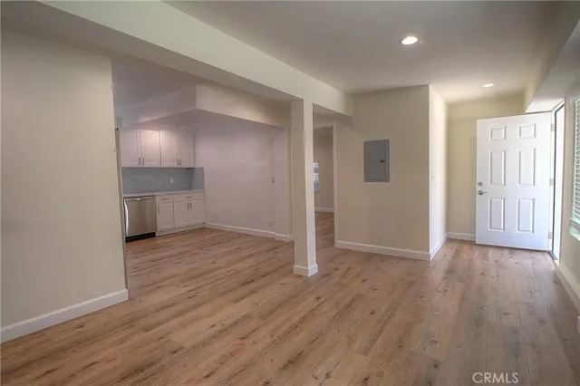 an empty room with wooden floor & windows