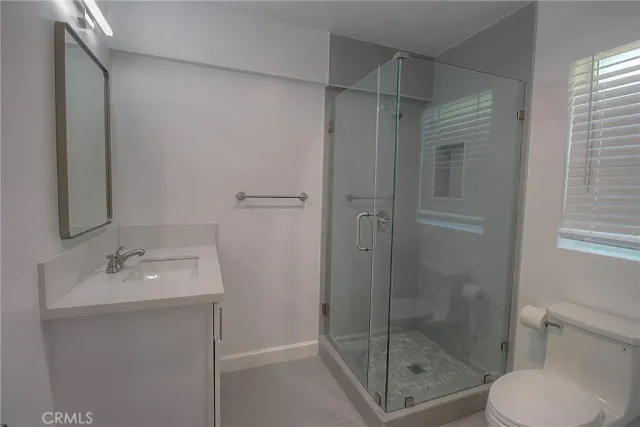 a bathroom with a shower a toilet and sink
