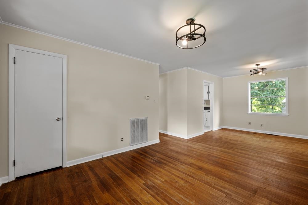 211 Drake Avenue Ripley, TN 38063 - Photo 7 of 25 an empty room with wooden floor cabinet and windows