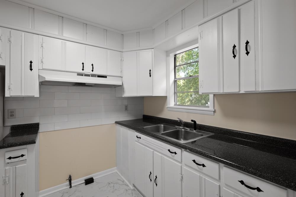 211 Drake Avenue Ripley, TN 38063 - Photo 10 of 25 a kitchen with granite countertop white cabinets white appliances and a sink