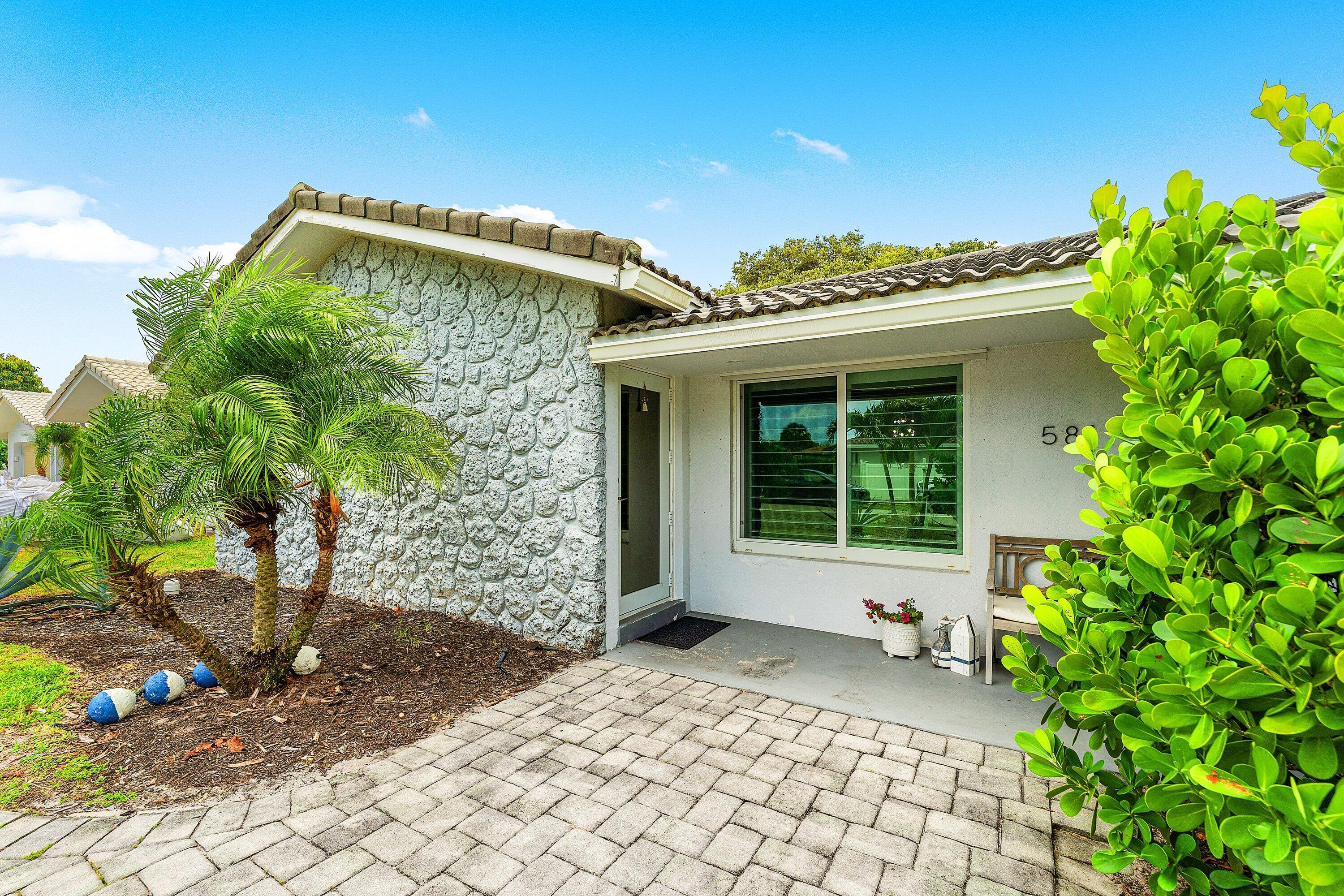 581 Northwest 13th Drive Boca Raton, FL 33486 - Photo 5 of 39 a front view of a house with a yard