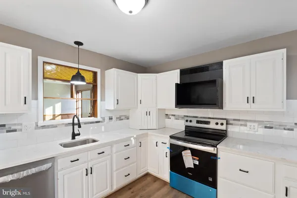 a kitchen with stainless steel appliances a stove sink microwave and cabinets