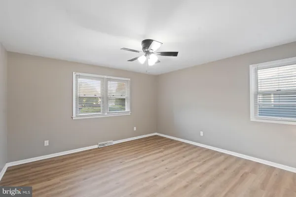 a view of a room with a ceiling fan and wooden floor