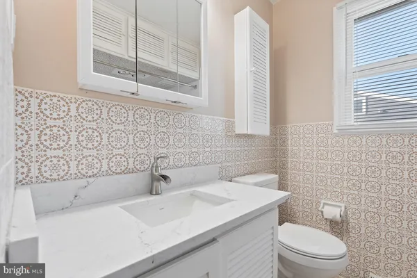 a bathroom with a sink a toilet and mirror