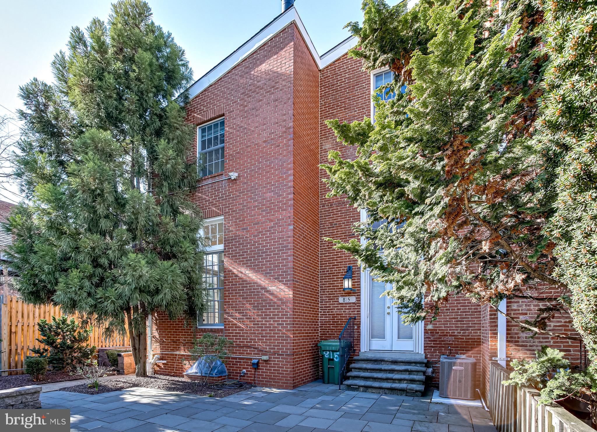 a front view of a house with a tree