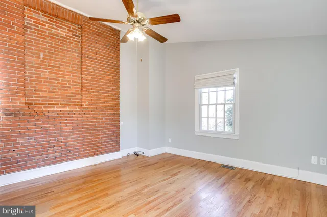 a view of a livingroom with wooden floor and a ceiling fan