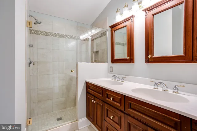 a bathroom with a double vanity sink mirror and shower