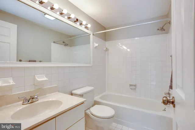 a bathroom with a sink a toilet a mirror and shower