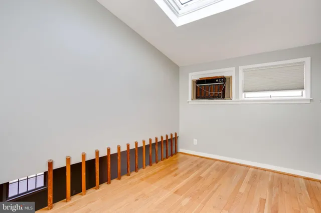 a view of a hallway with wooden floor and a window