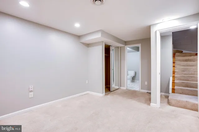 a view of a livingroom with wooden floor and stairs