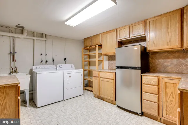 a utility room with cabinets washer and dryer