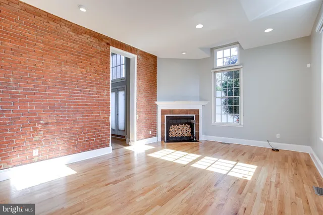 a view of empty room with wooden floor and fireplace