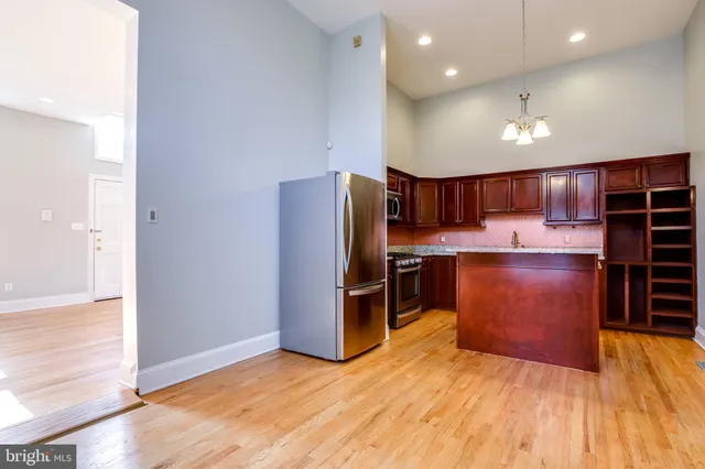 a kitchen with stainless steel appliances granite countertop a refrigerator a sink a stove a microwave and island