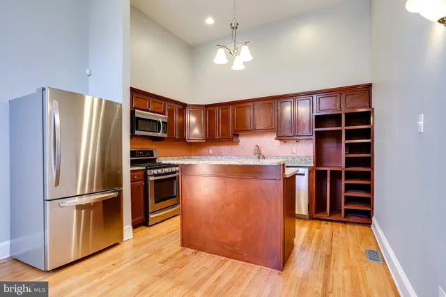 a kitchen with stainless steel appliances granite countertop a refrigerator and a stove top oven