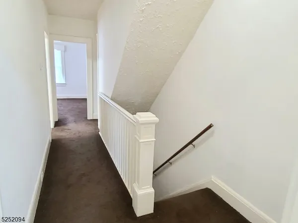 a view of a hallway with wooden floor and entryway
