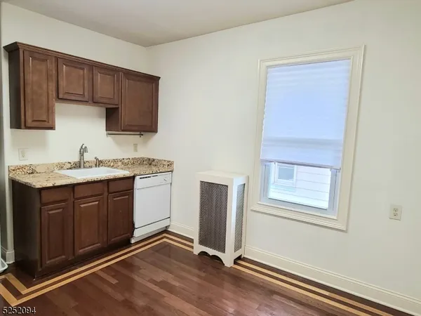 a kitchen with a sink cabinets and wooden floor