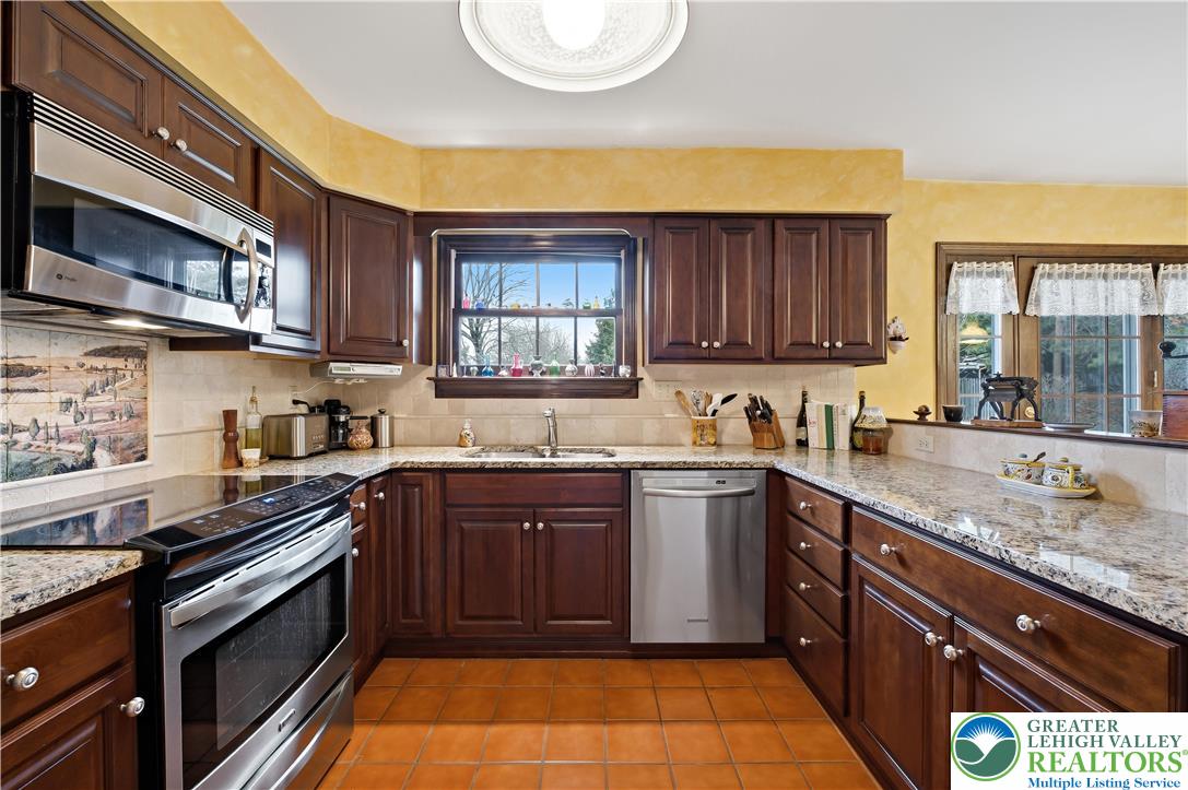 1700 Brandywine Road Allentown, PA 18104 - Photo 16 of 48 a kitchen with stainless steel appliances granite countertop wooden cabinets a stove top oven a sink and dishwasher