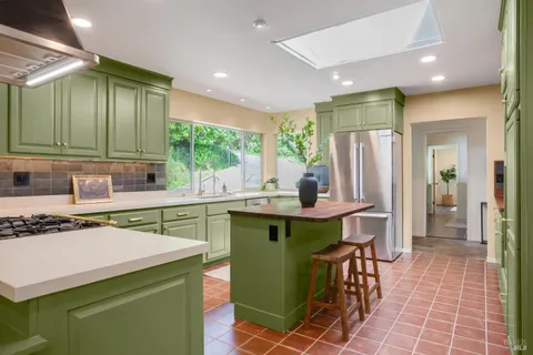 a kitchen with a sink a counter top space and stainless steel appliances