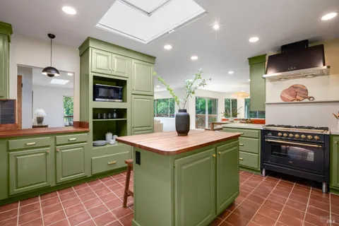 a kitchen with kitchen island a sink stove and cabinets