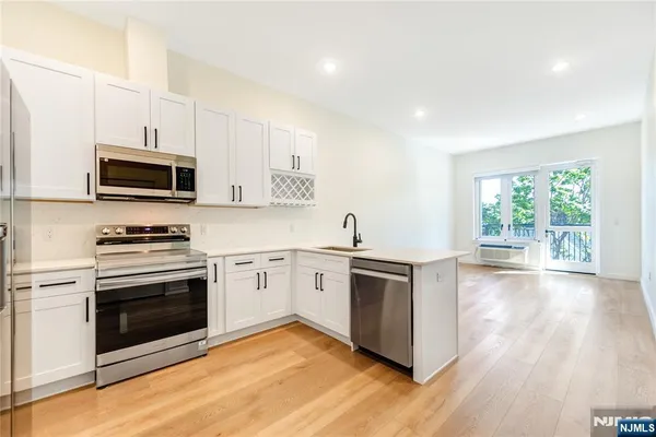 a kitchen with stainless steel appliances a refrigerator sink and microwave