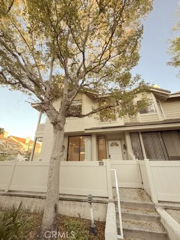 a front view of a house with a tree
