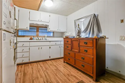 a kitchen with cabinets appliances and a wooden floor