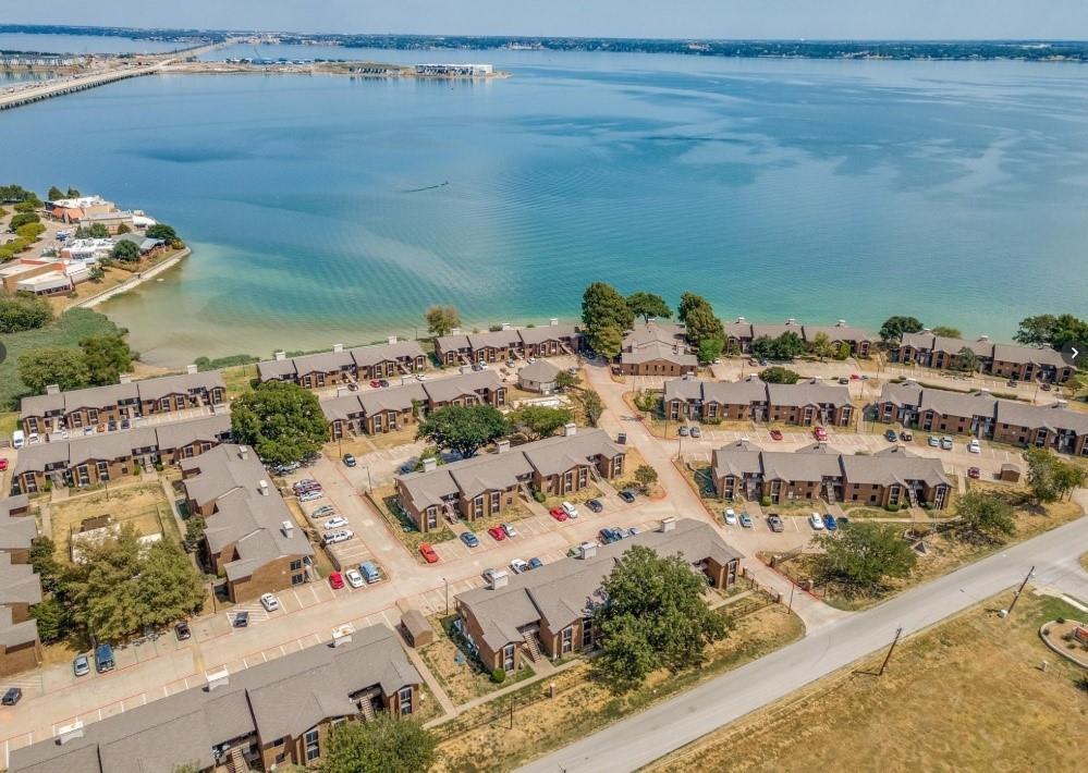 4448 Chaha Road Garland, TX 75043 - Photo 1 of 18 Waterfront community featuring contemporary townhome-style residences with modern architectural design, organized street layout with dedicated parking, mature landscaping throughout the neighborhood, and direct beach access with pristine sandy shoreline and expansive bay views