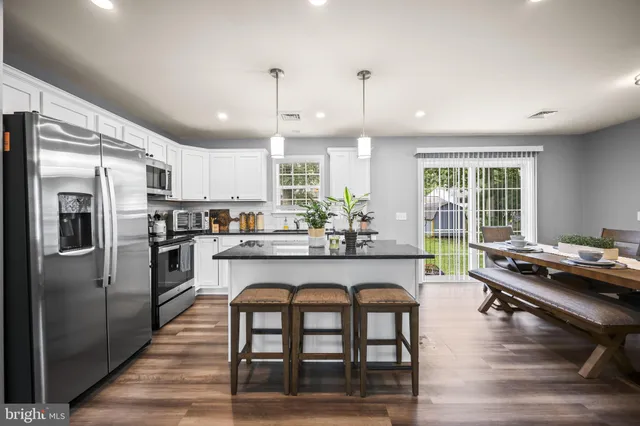 a kitchen with refrigerator a stove and chairs