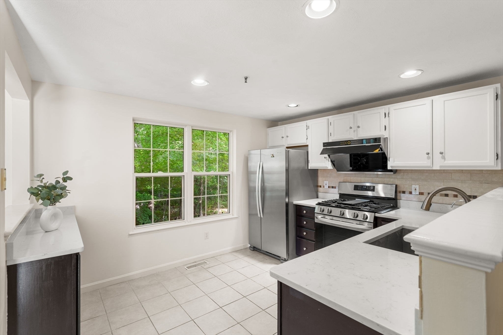 58 Meadowood Road North Andover, MA 01845 - Photo 12 of 31 a kitchen with stainless steel appliances a stove a sink a microwave a refrigerator and cabinets