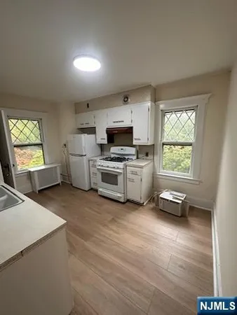 a kitchen with stove a microwave and white cabinets