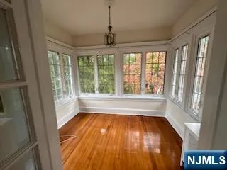 a view of wooden floor in an empty room with a window