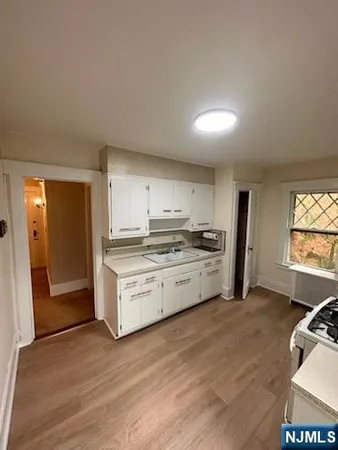 a kitchen with granite countertop white cabinets and white appliances