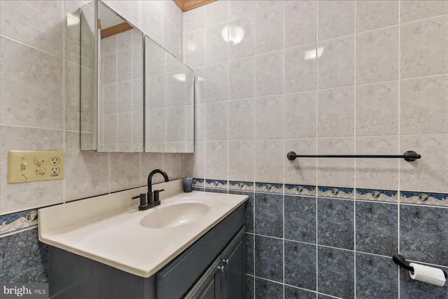 a bathroom with a sink shower and a mirror