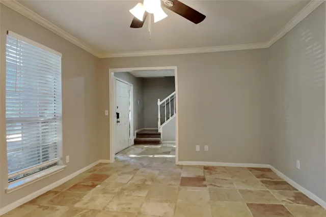 a view of a livingroom with a chandelier fan and windows