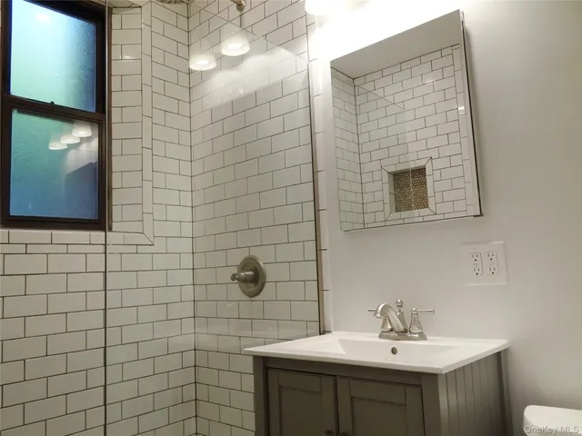 a bathroom with a sink shower and a mirror
