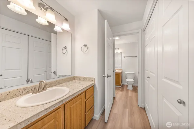 a en suite bathroom with a granite countertop sink and a mirror