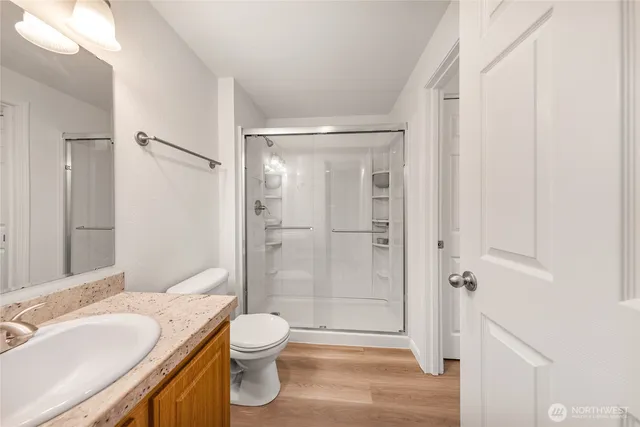 a bathroom with a granite countertop sink toilet and shower